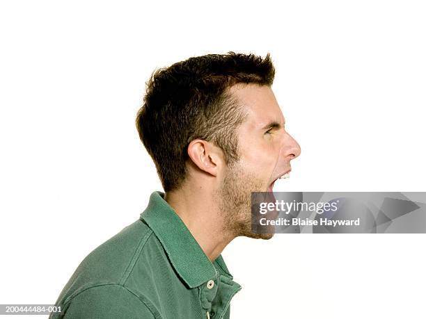 young man yelling, side view - schreeuwen stockfoto's en -beelden
