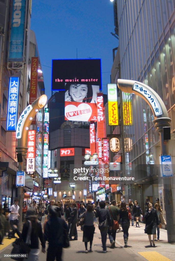 Japan, Tokyo, Shibuya Ward, people walking in street illuminated signs