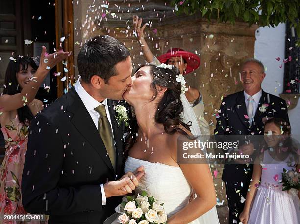 guests throwing confetti over kissing bride and groom, outdoors - church wedding decorations 個照片及圖片檔