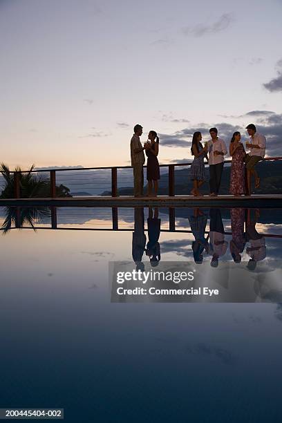 couples having cocktails beside pool, sunset - pool party night stock pictures, royalty-free photos & images