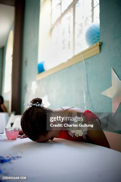 young woman in formal dress resting head on table, side view - head on table stock-fotos und bilder