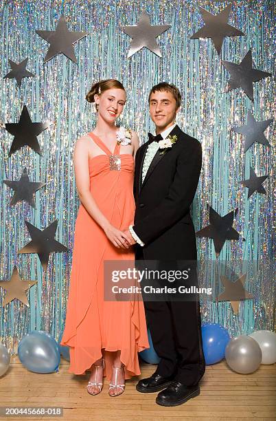 young man and woman in formalwear holding hands, portrait - prom fotografías e imágenes de stock