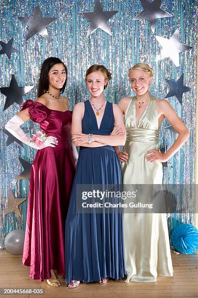 three teenage girls (16-18) wearing formal dresses, smiling, portrait - prom dress stockfoto's en -beelden