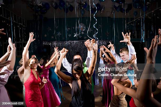 teenagers (15-18) in formalwear dancing at prom, arms raised - prom bildbanksfoton och bilder