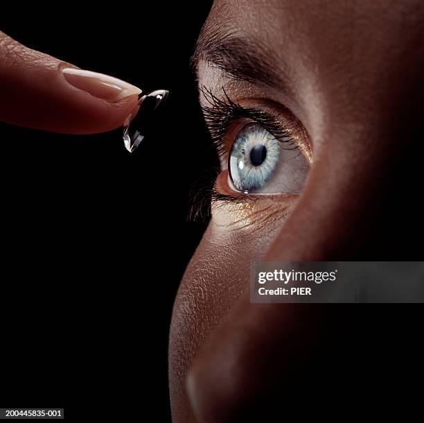 woman guiding contact lens into eye, close-up - contact lens stock pictures, royalty-free photos & images