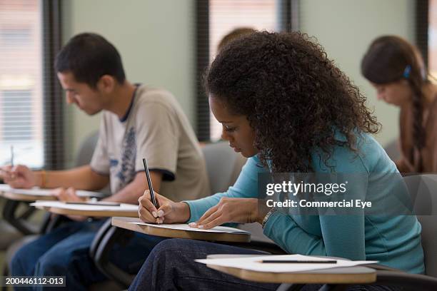 students taking written examination, side view - examinations imagens e fotografias de stock