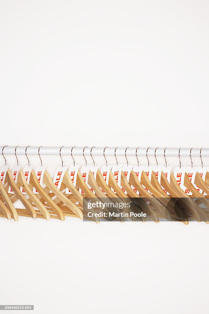 Clothes hangers with sale tags attached on clothes rail