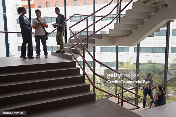 students talking on staircase landing - landing foto e immagini stock