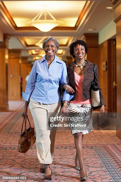 mother and adult daughter walking through hotel lobby - older women in short skirts stock pictures, royalty-free photos & images