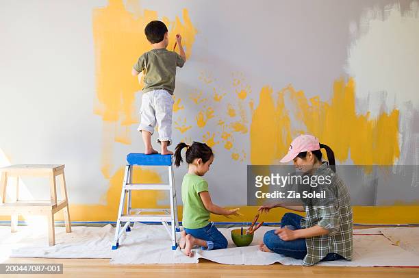 mother and children (2-6) painting living room wall - children room wall stock pictures, royalty-free photos & images