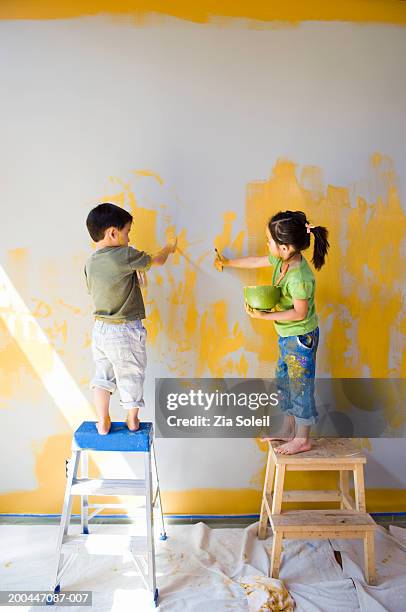 children (2-6) on ladders painting wall, rear view - boy barefoot rear view stockfoto's en -beelden