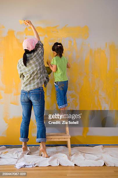 mother and daughter (4-6) painting wall, rear view - children room wall stock pictures, royalty-free photos & images