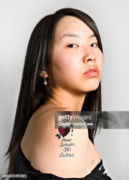 teenage girl (15-17) with tattoo on upper arm, portrait, close-up - tattoo shoulder stock pictures, royalty-free photos & images