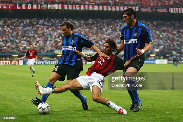 Rui Costa of AC Milan attempts a tackle in between Cristiano Zanetti and Massimo Materazzi of Inter Milan during the UEFA Champions League...