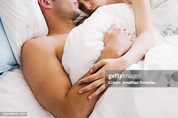 couple lying in bed, close-up - pareja abrazados cama fotografías e imágenes de stock