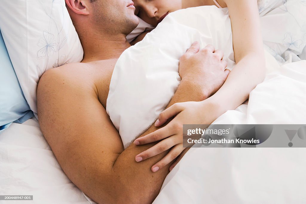 Couple lying in bed, close-up