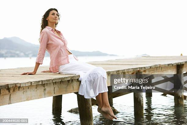 young woman relaxing on jetty - long white skirt stock pictures, royalty-free photos & images