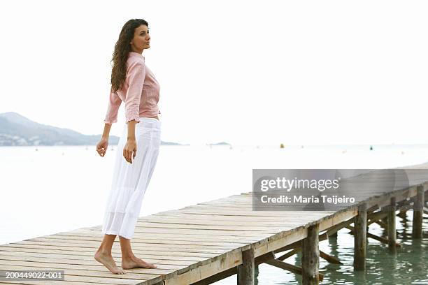 young woman standing on jetty - falda blanca fotografías e imágenes de stock