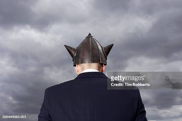 man wearing metal 'viking' helment, rear view - viking stock pictures, royalty-free photos & images