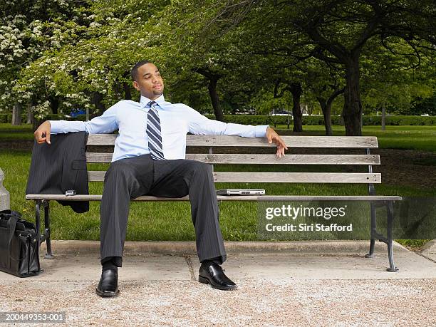 young businessman relaxing on park bench - suit and tie stock pictures, royalty-free photos & images