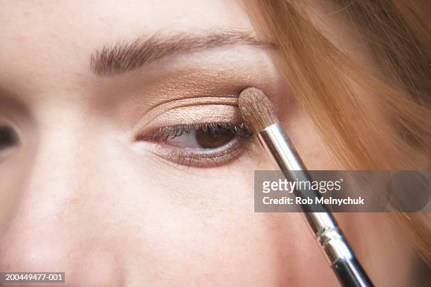 teenage girl (16-18) applying eyeshadow, close-up of eye - applying makeup with brush stock pictures, royalty-free photos & images