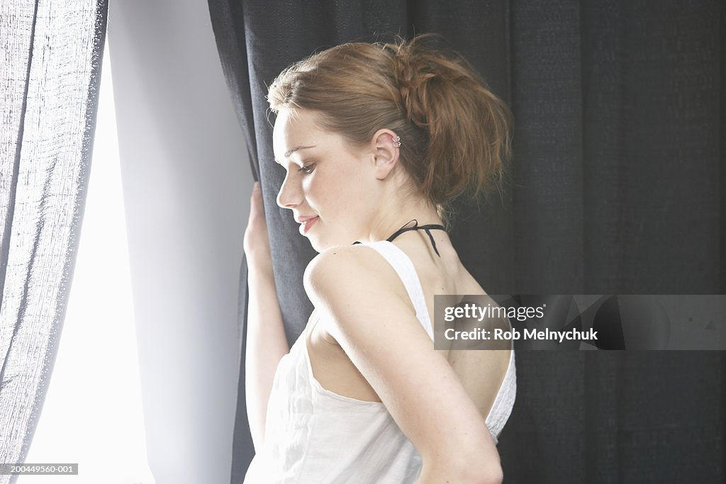 Teenage model (16-18) walking through curtain onto runway