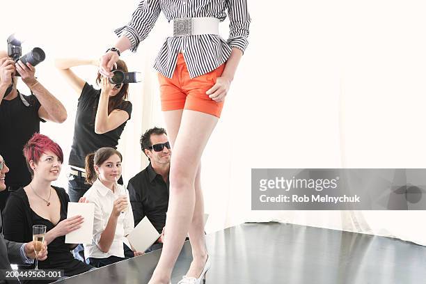 photographers and spectators watching model on runway at fashion show - kids catwalk stock pictures, royalty-free photos & images