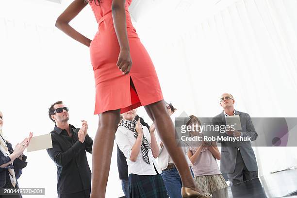 spectators applauding for female model on runway at fashion show - kids catwalk stock pictures, royalty-free photos & images