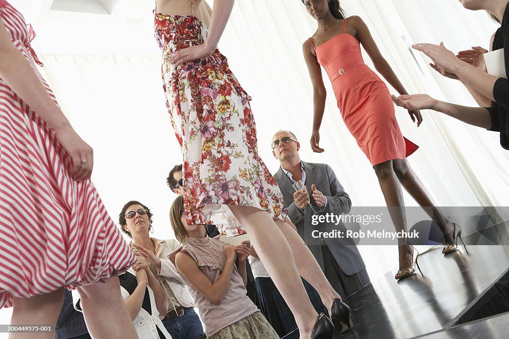Spectators applauding for models on runway during fashion show