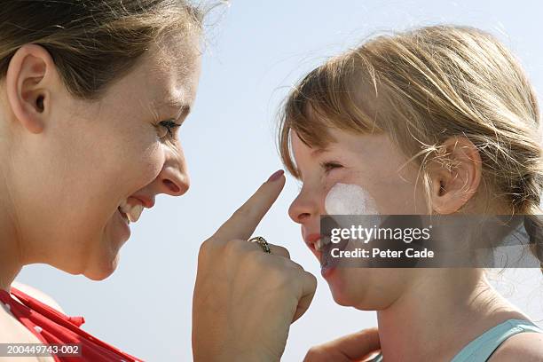 mother applying sun cream to daughter's (3-5) face, close-up - spf 30 stock-fotos und bilder