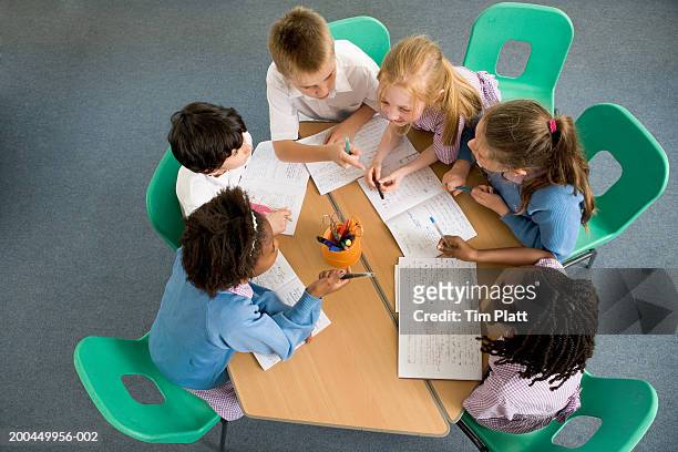 children (7-12) sitting around table, having discussion, elevated view - bambini seduti in cerchio foto e immagini stock