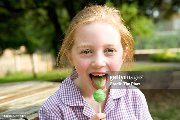 girl (7-9) licking green lollipop, portrait - girls licking girls stock pictures, royalty-free photos & images