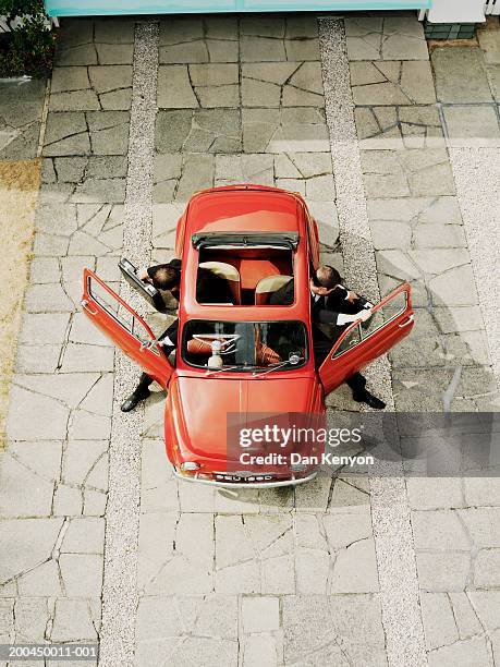 men getting out of red car, overhead view (digital composite) - soltak bildbanksfoton och bilder