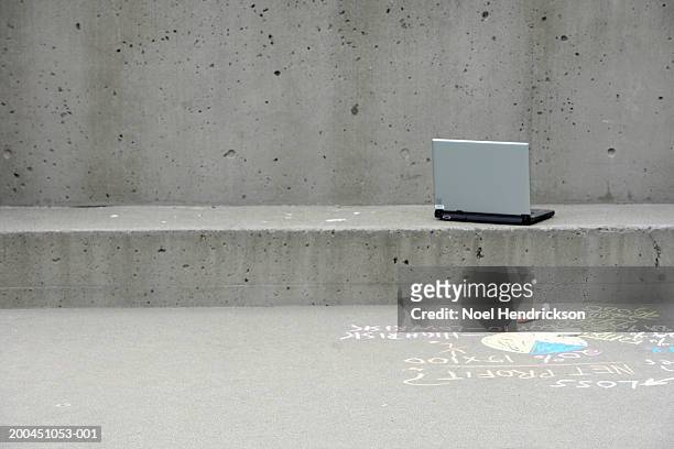 laptop outside building with writing on sidewalk - sims stock-fotos und bilder