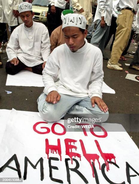 Indonesian Muslim protestors from the militant "Front for the Defenders of Islam" perform mid-day prayer during a protest in front of the...