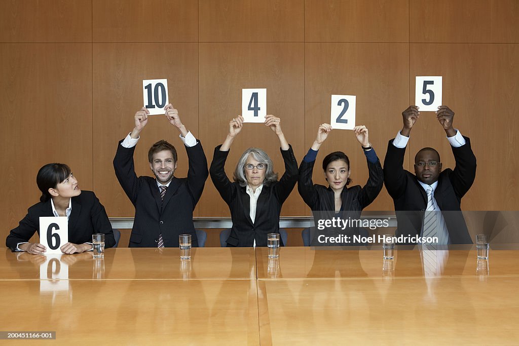 Business colleagues holding up cards with numbers