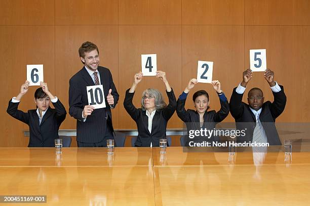 business colleagues holding up cards with numbers, man standing - description bildbanksfoton och bilder