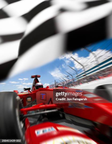 man driving open-wheel single-seater racing car race car under flag (digital composite) - finish line car stock pictures, royalty-free photos & images