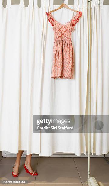 dress hanging outside dressing room, woman changing inside room - womens blouse stock pictures, royalty-free photos & images