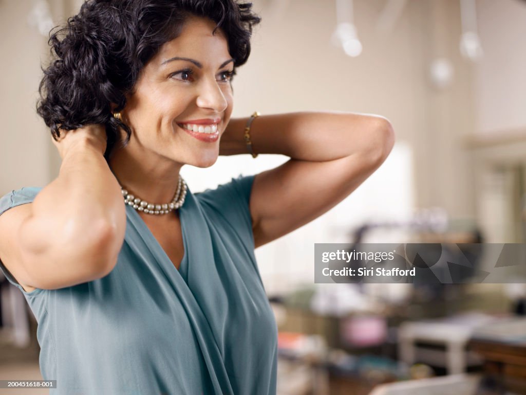 Mujer tratando en pearl necklace cliente en la tienda