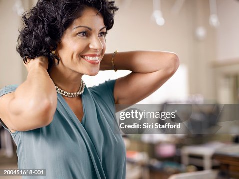 Female customer trying on pearl necklace in shop Female customer trying on pearl necklace in shop