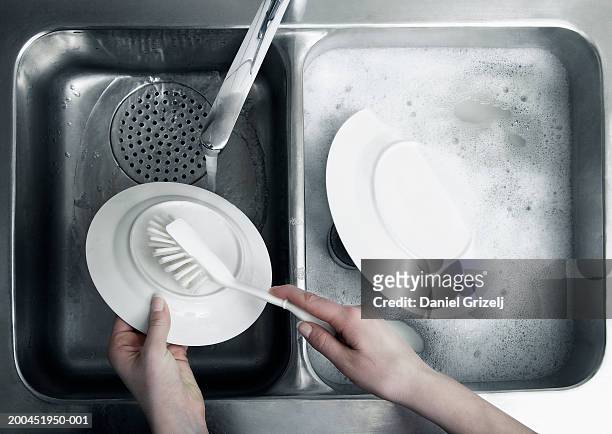 woman washing up plate at sink, close-up - wash the dishes stock pictures, royalty-free photos & images