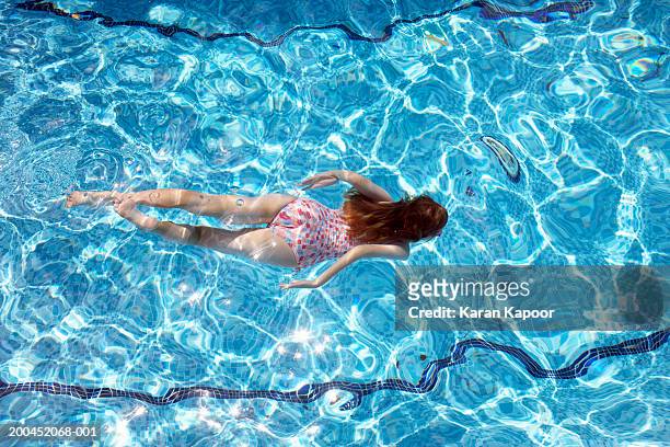 girl (8-10) swimming underwater in pool, overhead view - resort pool stock pictures, royalty-free photos & images