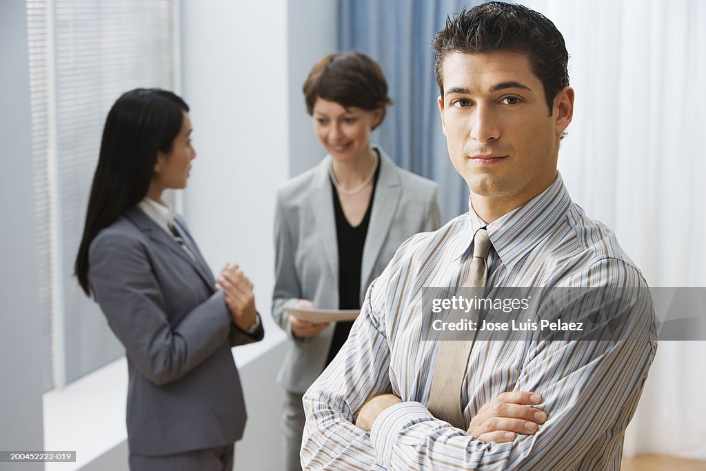 Businessman portrait, businesswomen talking