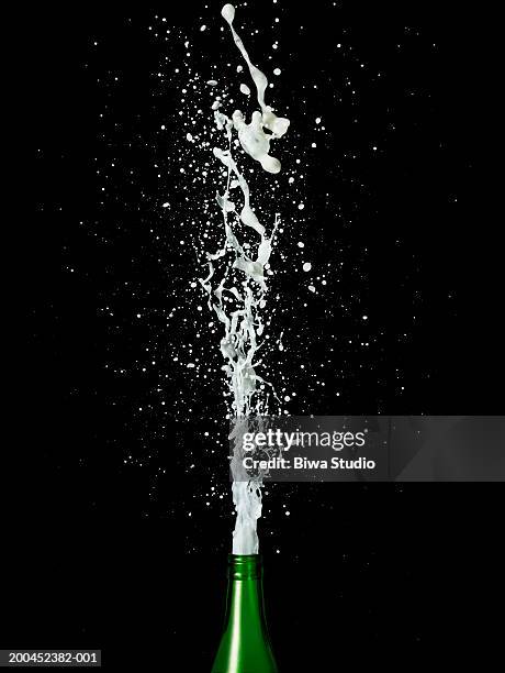 champagne spraying from bottle - bulles champagne photos et images de collection
