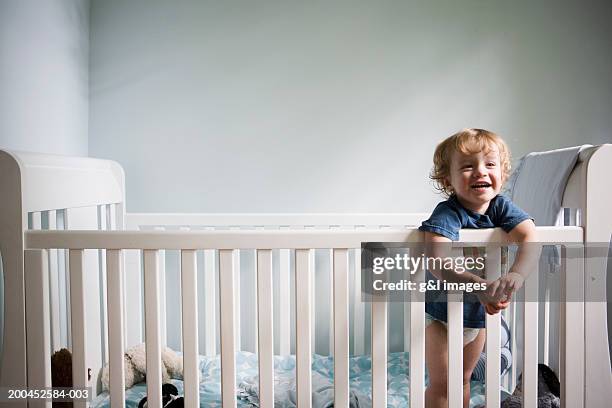 toddler boy (21-24 months) smiling in crib, close-up - babybett stock-fotos und bilder