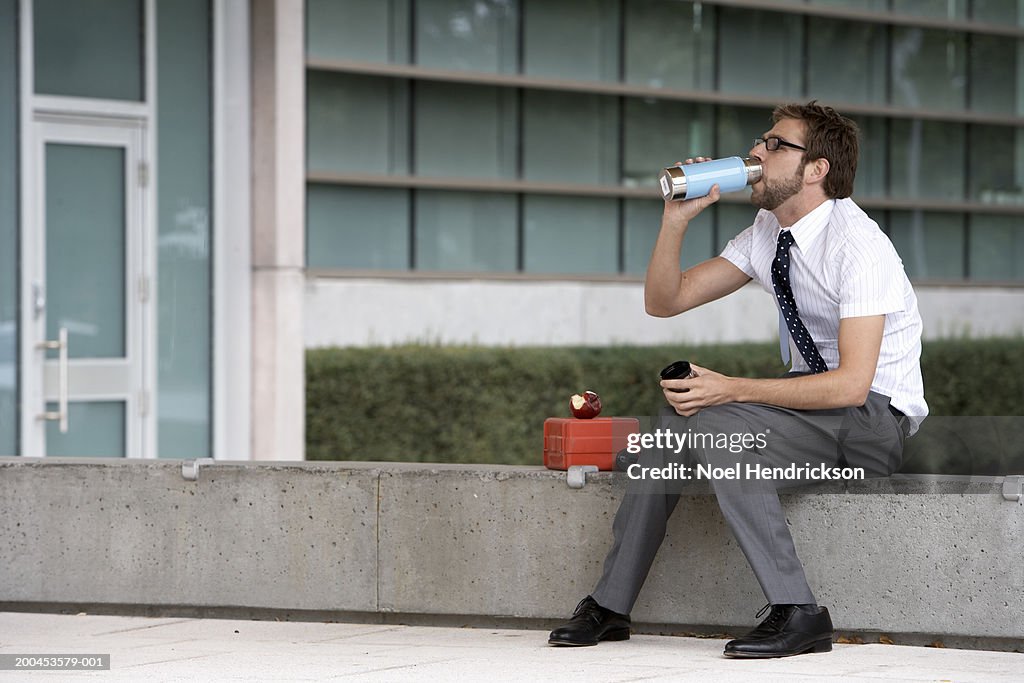 Businessman drinking from thermos