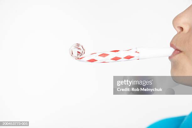 boy (10-12) blowing noisemaker, side view, mid section - roltong stockfoto's en -beelden