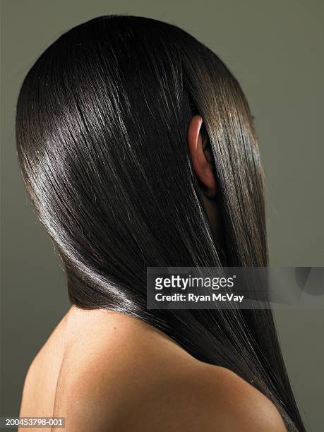 young woman with ear sticking out of long hair, side view - cabello negro fotografías e imágenes de stock