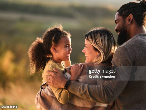 happy diverse parents enjoying with their daughter in autumn day. - family and happiness and diverse - fotografias e filmes do acervo